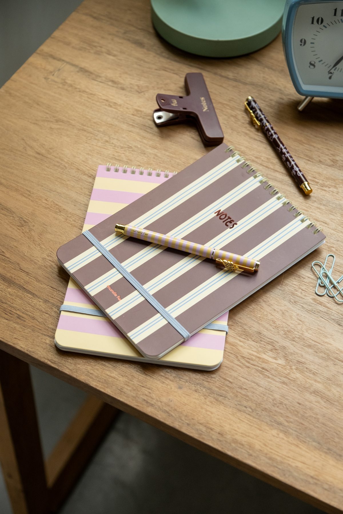 Cuadernos y lapicera sobre una mesa de madera